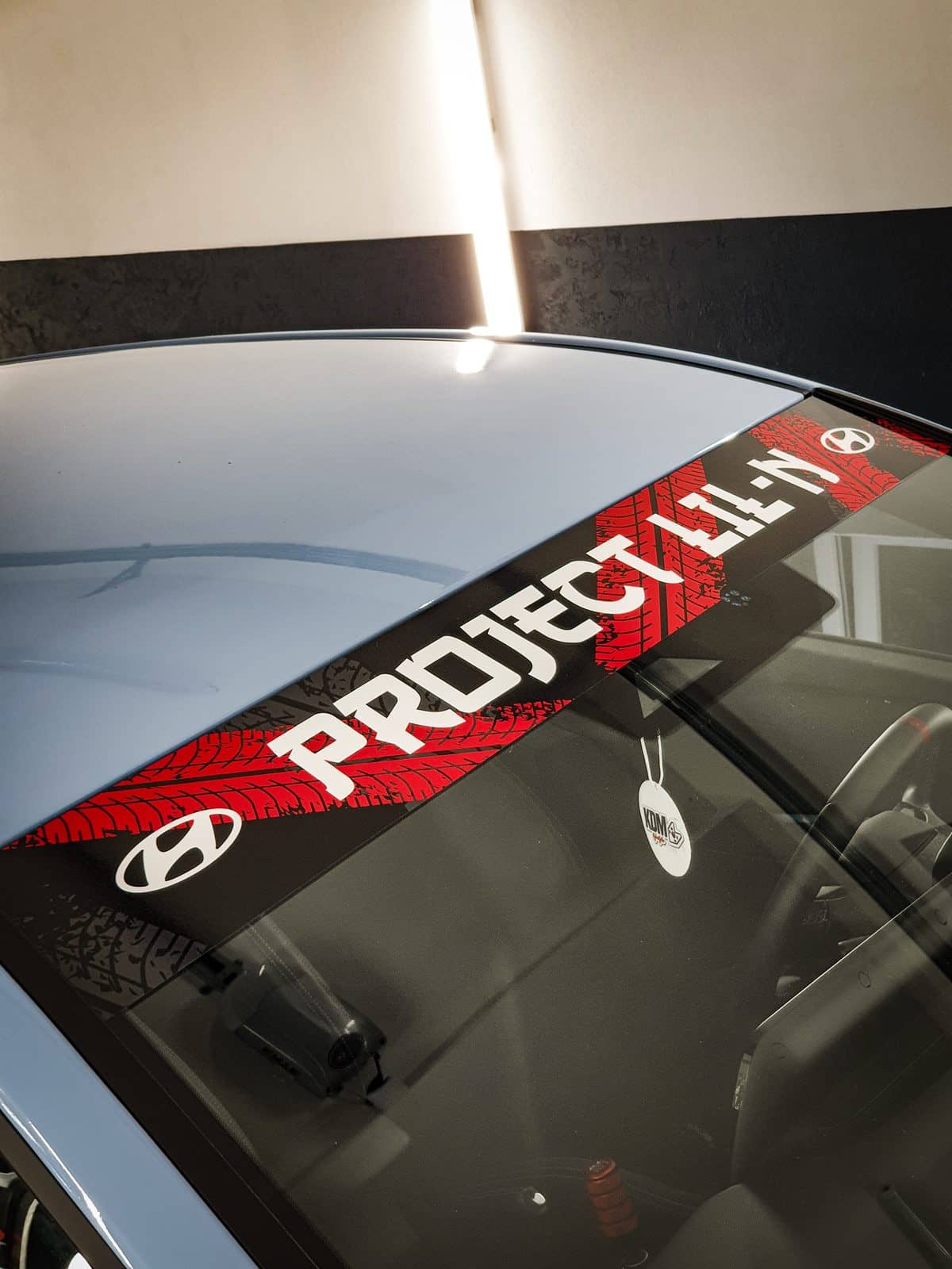 Červený sunstrip s nápisom PROJECT LIL-N a logom Hyundai na čelnom skle