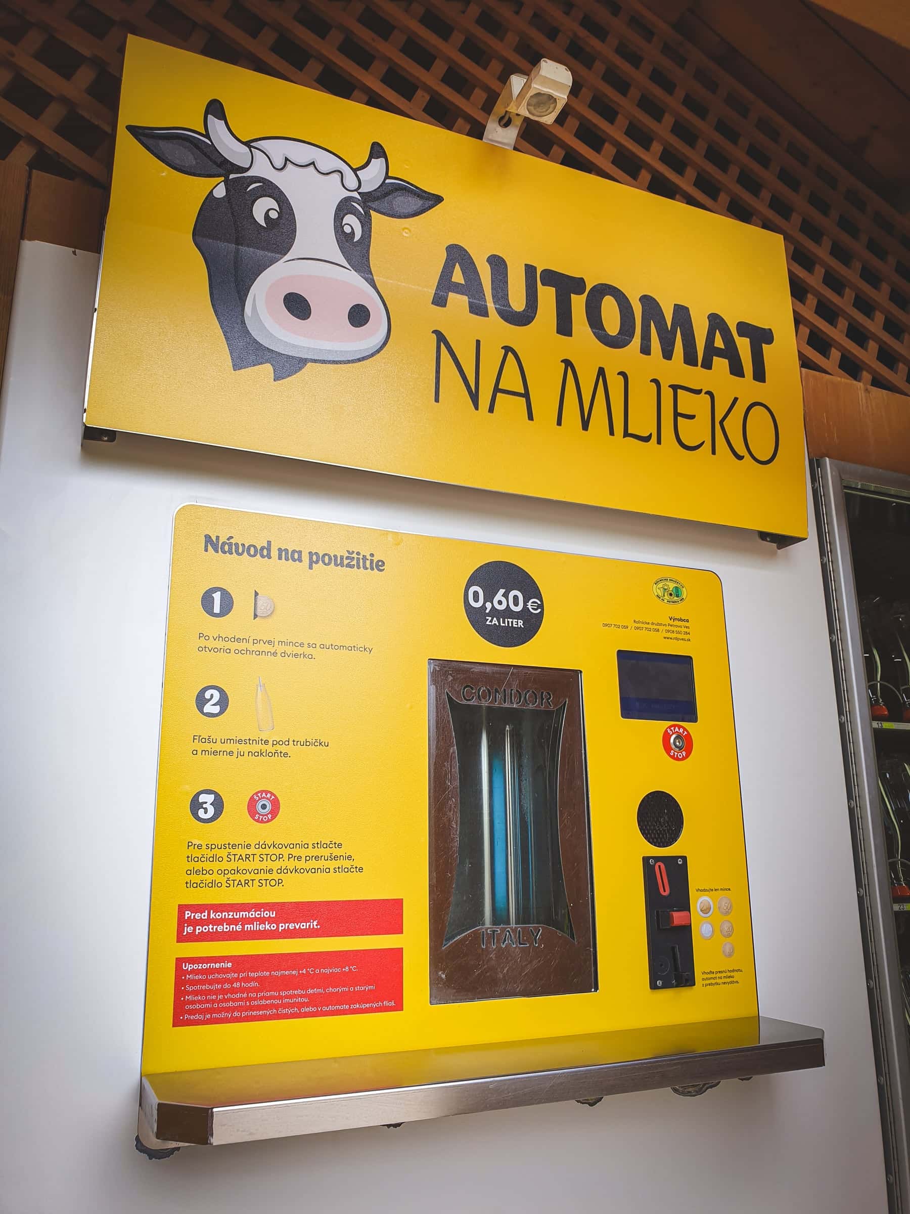 Žltý polep automatu na mlieko s kravičkou a návodom na použitie