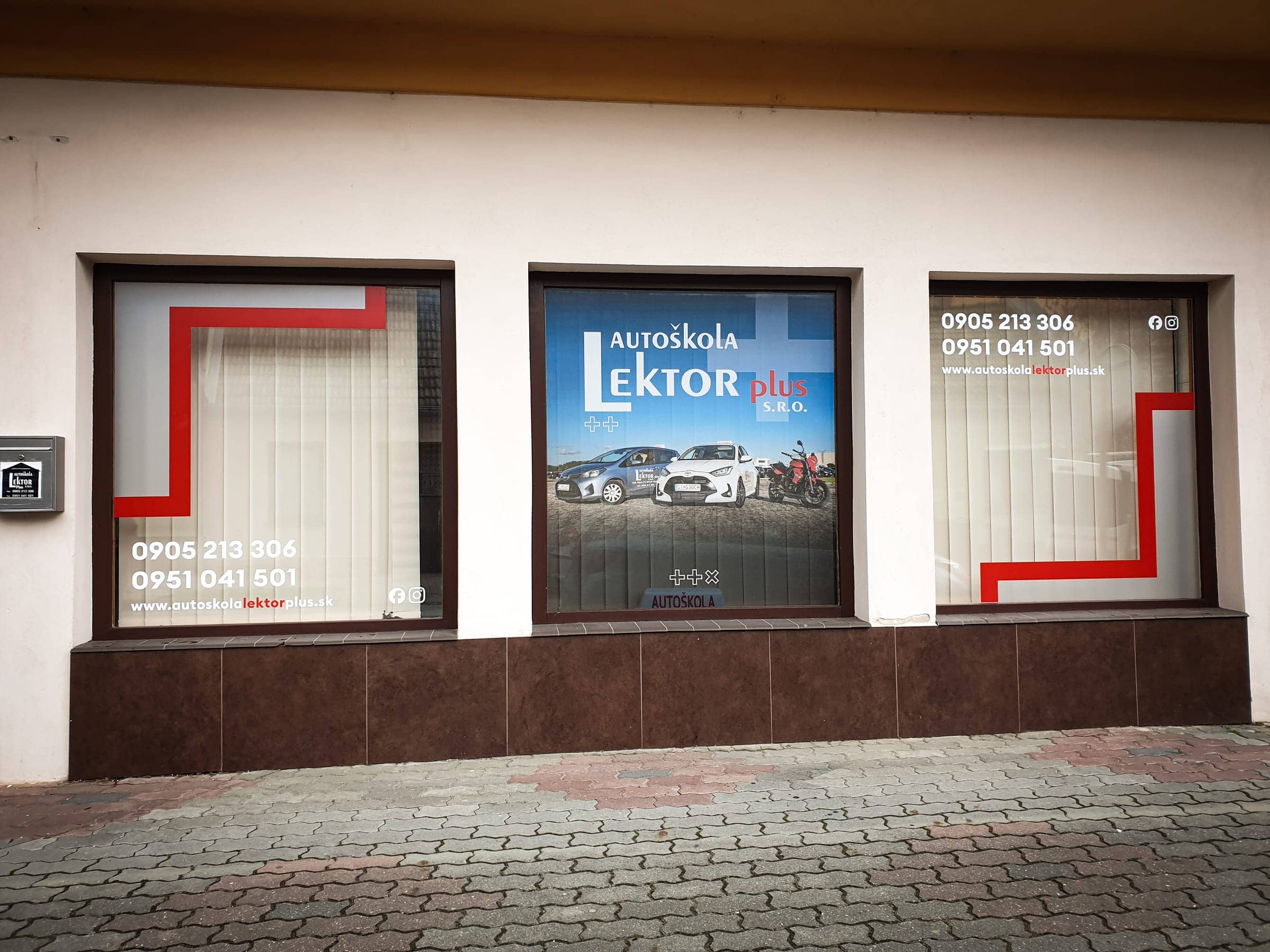 Polep troch výkladov autoškoly Lektor plus s logom, fotkou áut, kontaktmi a červenými pruhmi