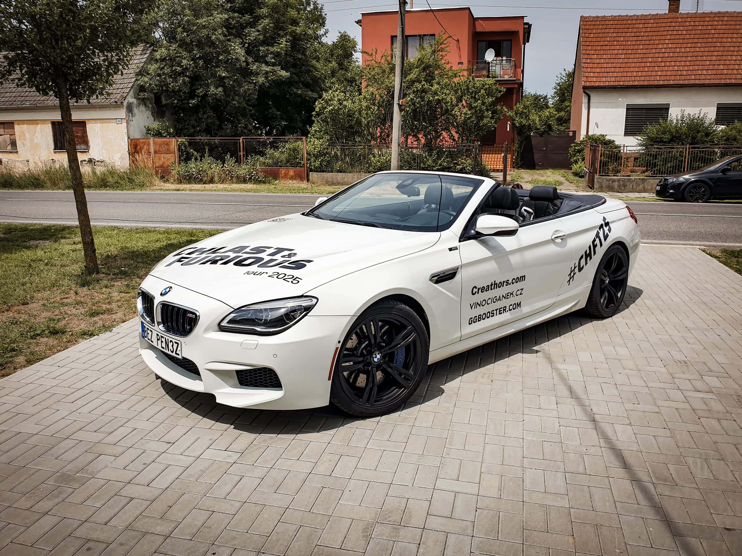 Biely kabriolet BMW M6 s polepom Fast & Furious Jam 2025 a logami sponzorov