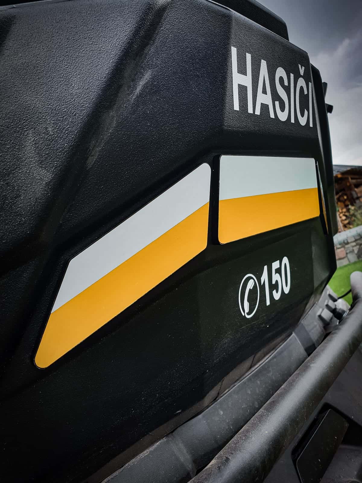 Nápis HASIČI, žlto-biele pruhy a číslo 150 na hasičskej technike