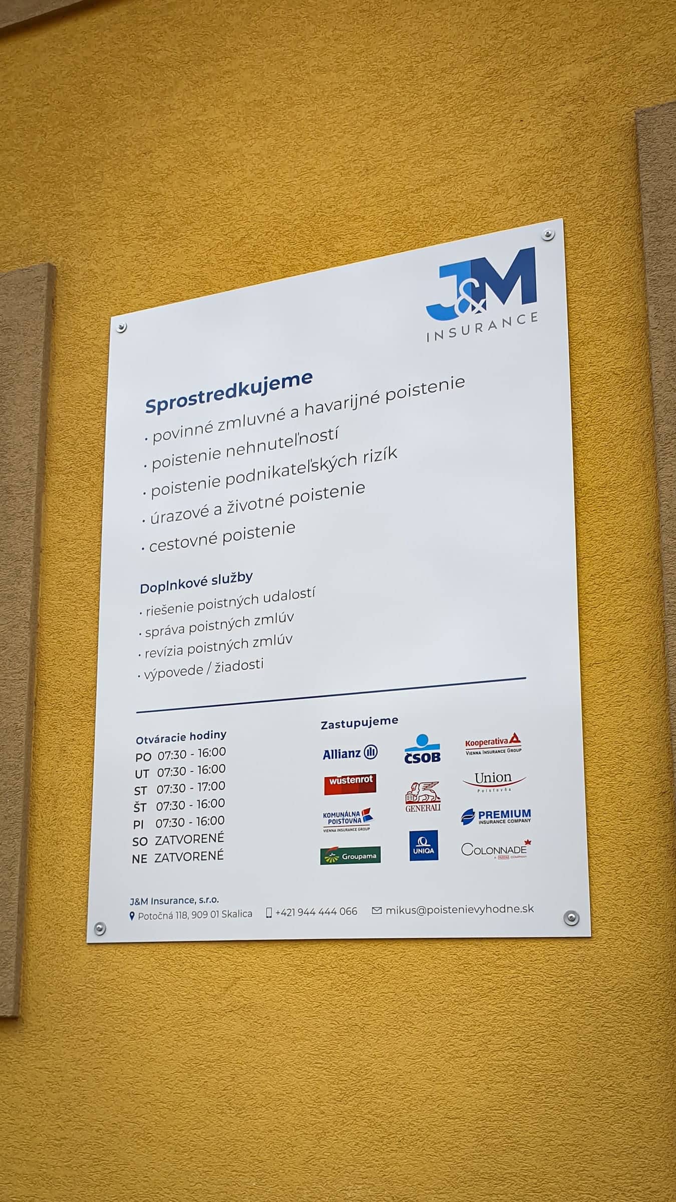 Cedula J&M Insurance s ponukou poistenia a otváracími hodinami na žltej fasáde