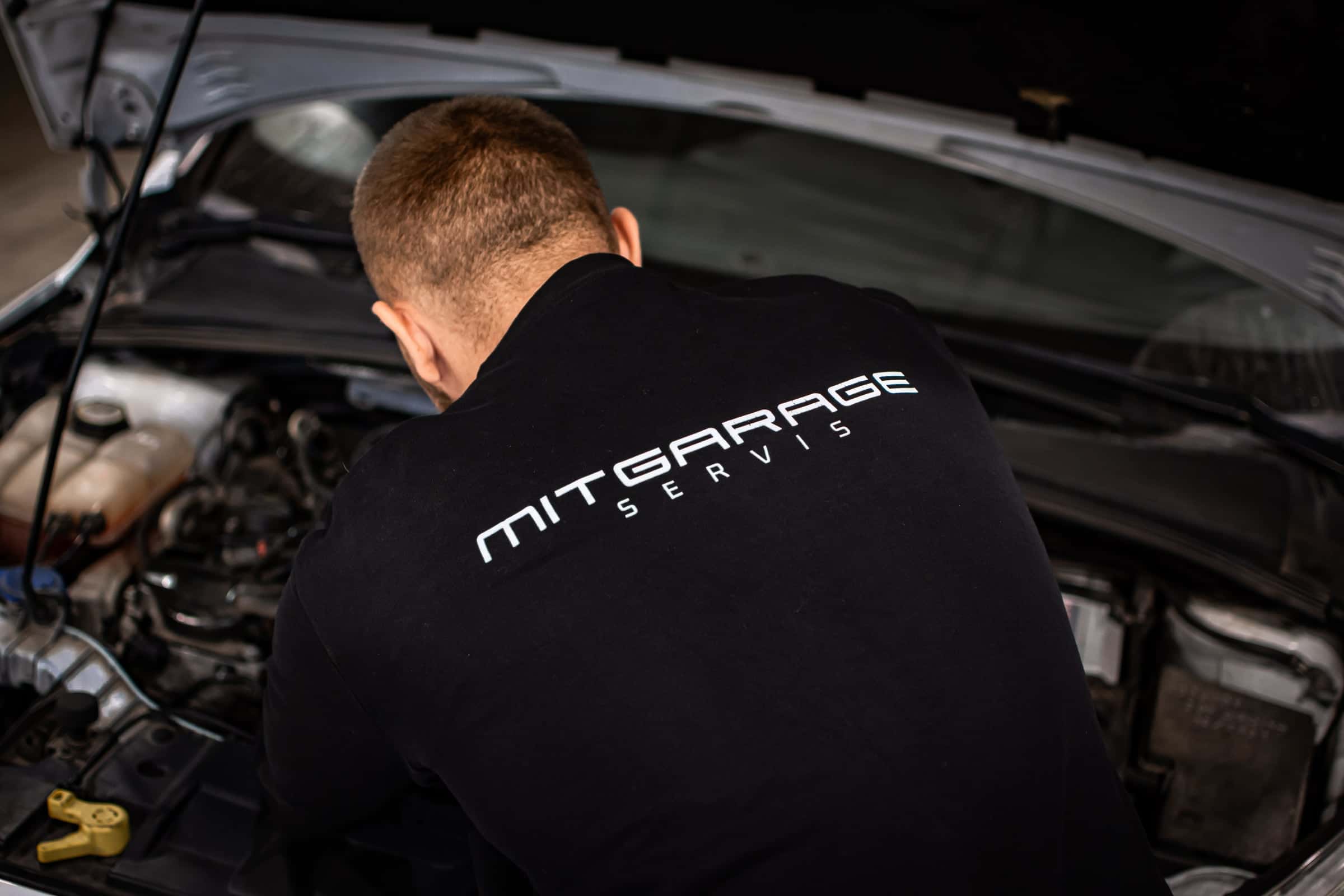 Mechanik v mikine MITGARAGE servis nad motorom