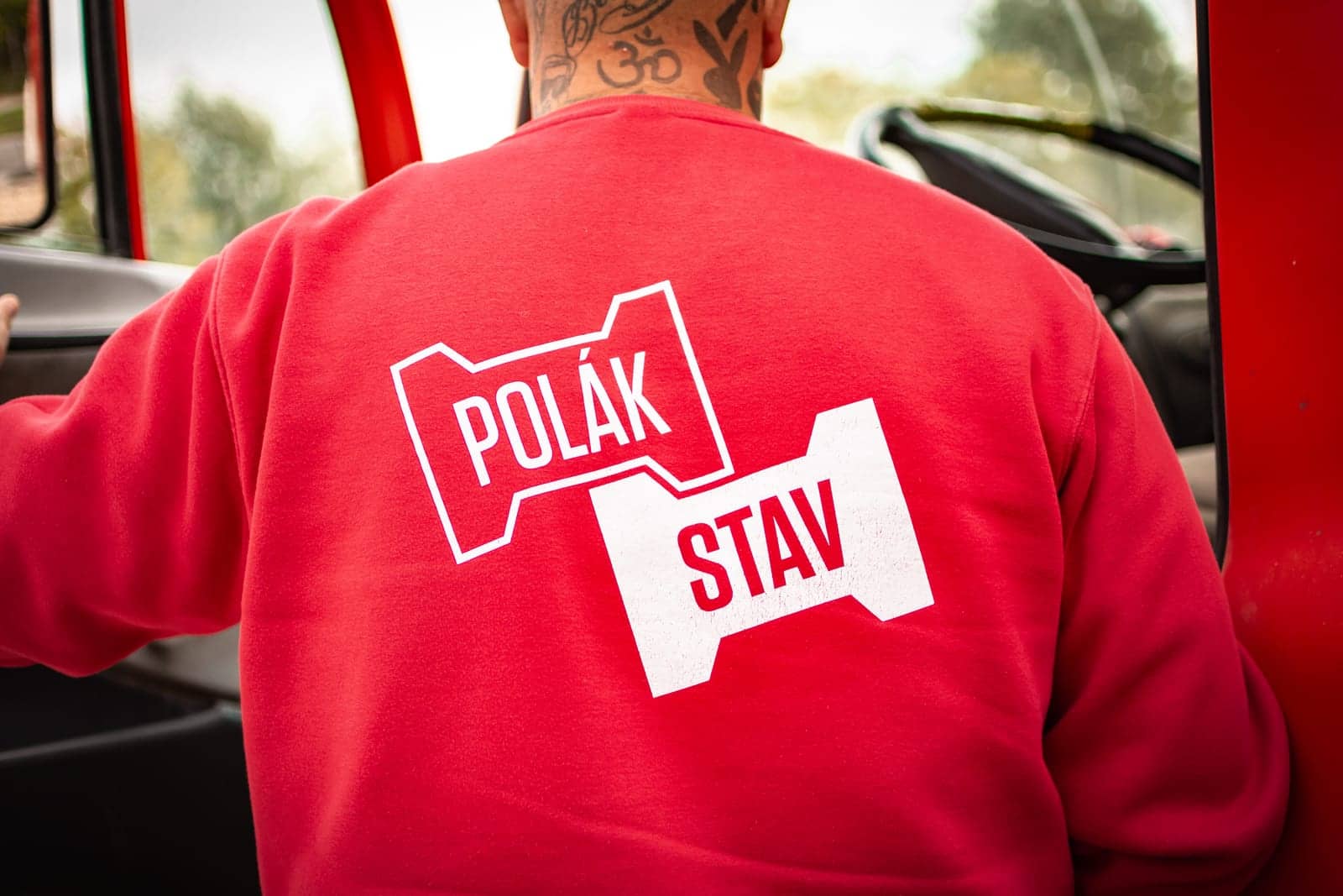 Červená mikina s bielym logom POLÁKSTAV na chrbte v kabíne stroja