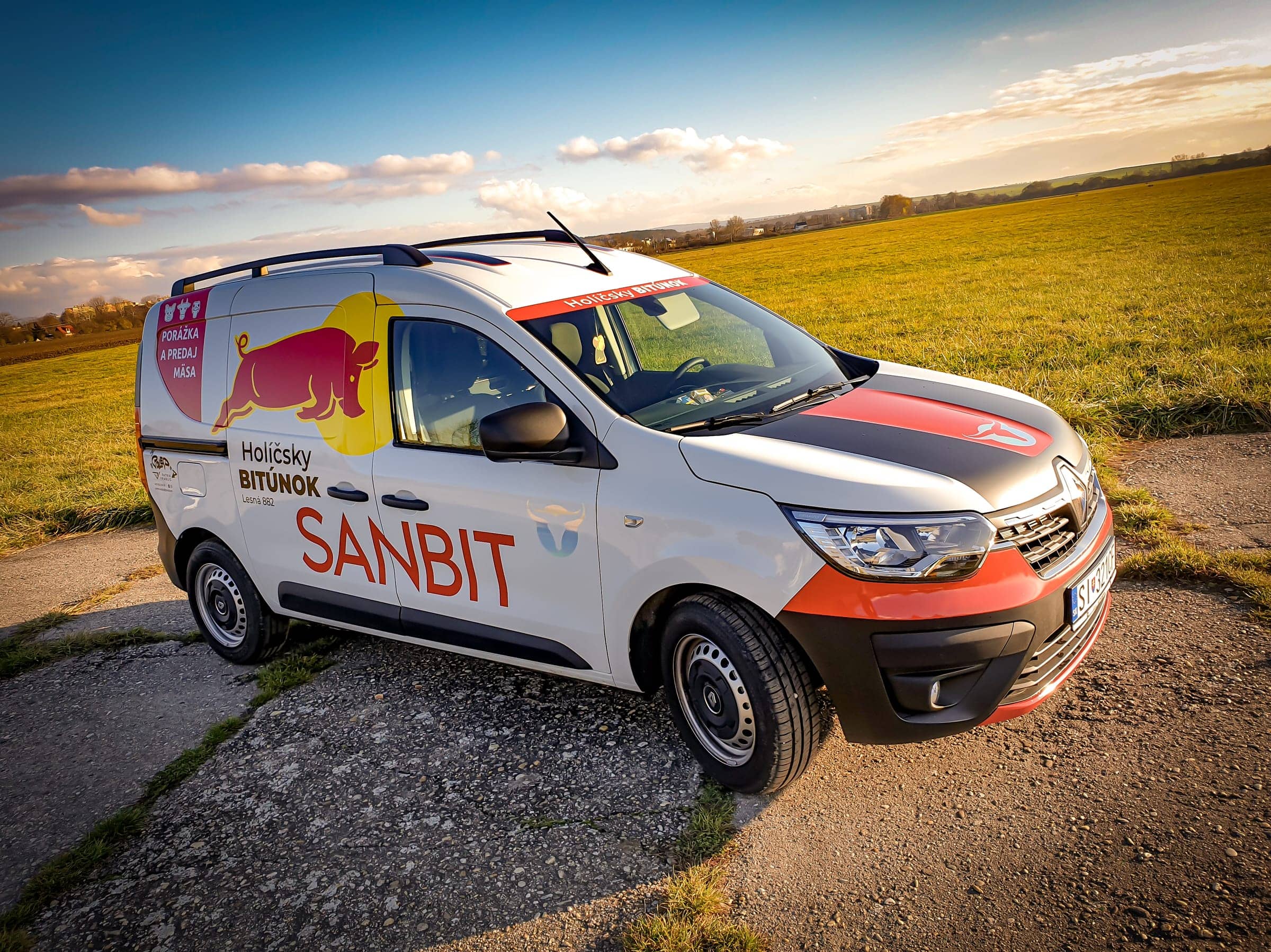 Renault Express s polepom SANBIT – Holíčsky bitúnok na poli pri západe slnka, pohľad zhora